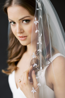 Dainty paillette leaves and sequin flowers trail the border of this classic chapel silhouette.